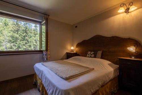 a bedroom with a large bed and a window at Alpine Forest Hotel in Champoluc