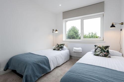 a bedroom with two beds and a window at Scandi Inspired Home In Eccles in Manchester