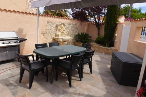 une table et des chaises avec un parasol sur une terrasse dans l'établissement VILLA Ô Chris spacieuse, 2 Terrasses, 1 SPA, à 15 mn de Marseille, de la Côte bleu et Aix en Provence, à Saint-Victoret