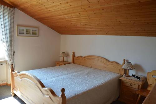 una camera con letto e soffitto in legno di AlpenGlück – **** Ferienwohnung a Siegsdorf