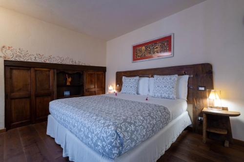 a bedroom with a large bed with blue and white sheets at Domus Antica Aosta in Aosta