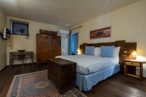 a bedroom with a large bed with blue pillows at Domus Antica Aosta in Aosta