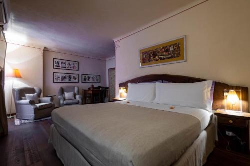 a bedroom with a large bed and two chairs at Domus Antica Aosta in Aosta