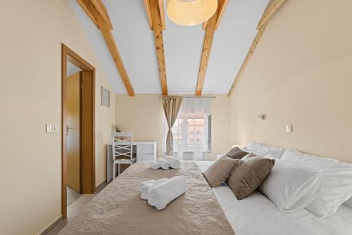 una camera da letto con un grande letto bianco con due asciugamani di Apartman Žužić a Novigrad Istria