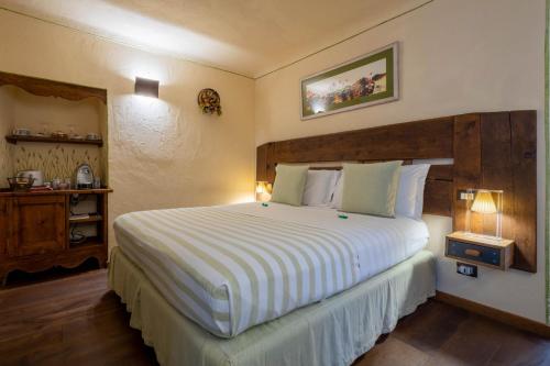 a bedroom with a large bed with a wooden headboard at Domus Antica Aosta in Aosta