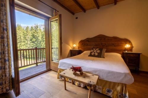a bedroom with a bed and a large window at Alpine Forest Hotel in Champoluc