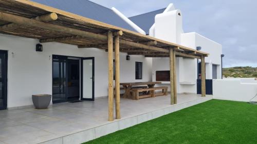 an outdoor patio with a wooden pergola at C-Rock Holiday Home Jacobs Bay in Jacobs Bay