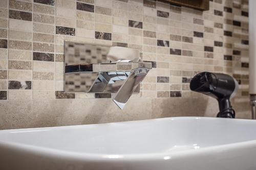 a bath tub with a faucet next to a sink at Domus Antica Aosta in Aosta