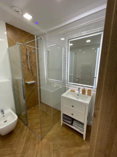 a bathroom with a sink and a shower and a toilet at Route 7 Rooms in Myślenice