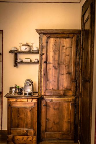 an old wooden cabinet in a kitchen with a stove at Domus Antica Aosta in Aosta