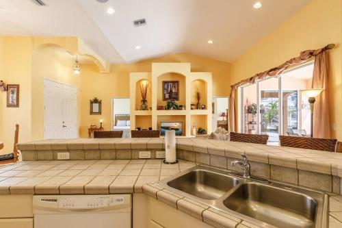 een keuken met een spoelbak en een aanrechtblad bij Villa Maxos - Boaters dream 4br/3 bath pool / spa in Cape Coral