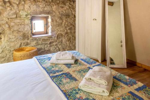 1 dormitorio con 1 cama con toallas en Casa de Pedra Casa rural en el Alt Empordà, en Cantallops