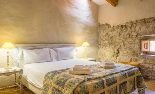 1 dormitorio con 1 cama con 2 toallas en Casa de Pedra Casa rural en el Alt Empordà, en Cantallops