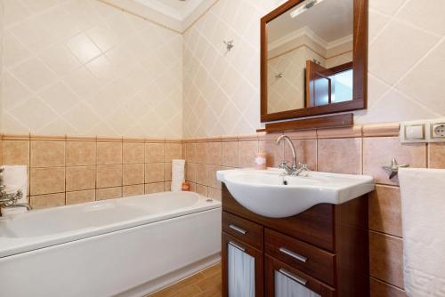 W łazience znajduje się umywalka, wanna i lustro. w obiekcie Brisa del Mar w mieście Guía de Isora