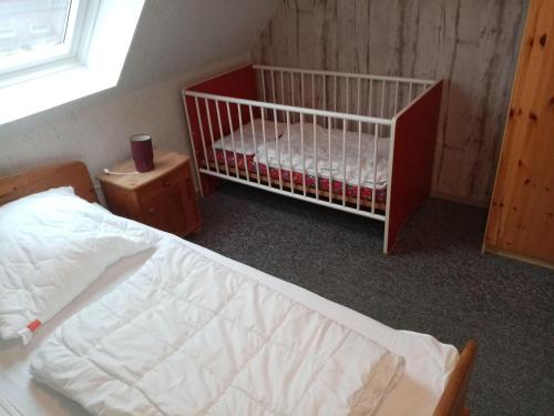 - une chambre avec un lit bébé et une fenêtre dans l'établissement Nordsee-Ferienanlage-Wohnung-Baltrum, à Dornumersiel
