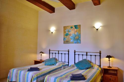 two beds sitting next to each other in a room at Villagg tal-Fanal in Għasri