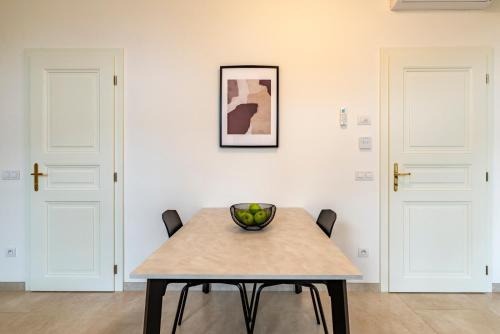 a dining room table with a bowl of fruit on it at Petrin Tower Residence in Prague