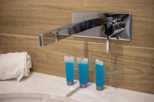 um lavatório de casa de banho com três copos de líquido azul em Okopowa Blue Apartment em Varsóvia