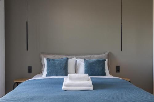 uma cama azul com uma pilha de toalhas em Okopowa Blue Apartment em Varsóvia