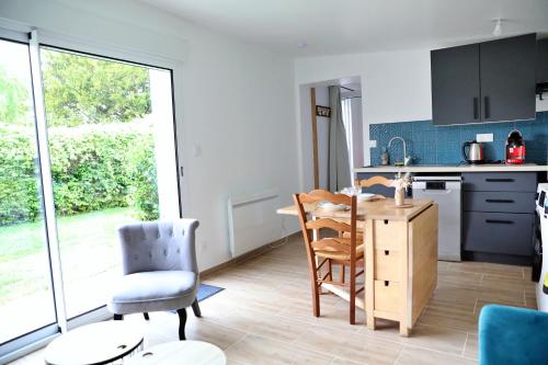 kuchnia ze stołem i krzesłami w pokoju w obiekcie Gîte Les amoureux de la Baie w mieście Favières