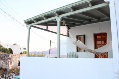 a porch with a hammock on a house at Lithi Stylish Apartments- Eco Luxury Suite in Tripití