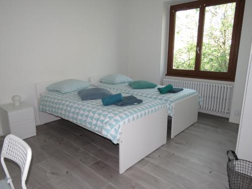 a bedroom with a bed with blue pillows and a window at "La Scierie" T4 80m2 Annecy in Annecy