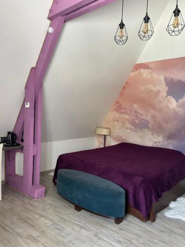 Un dormitorio con una cama morada y una pintura en Le Montmieri, en Dax