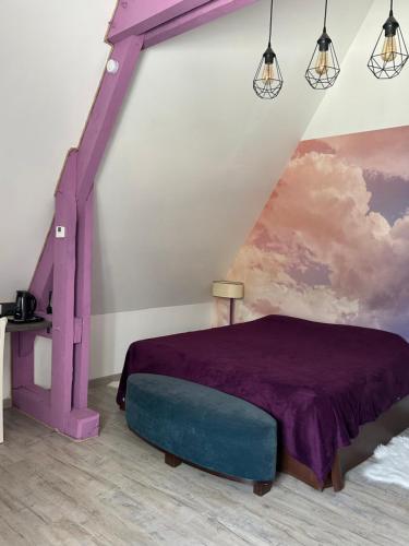 - une chambre avec un lit violet et un tableau dans l'établissement Le Montmieri, à Dax