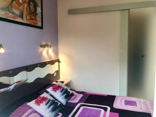 - une chambre avec un lit doté d'oreillers violets et blancs dans l'établissement Villa 16, Port Vénus au village naturiste, au Cap d'Agde