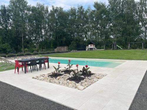 a pool with a table and chairs next to a picnic table at Noble Apartment & Sauna ZONE in Zabierzów
