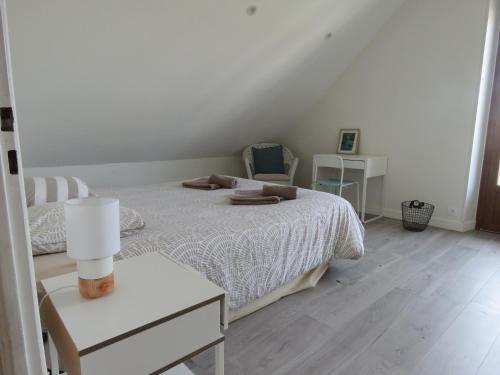 een witte slaapkamer met een bed en een tafel bij "La Scierie" T4 80m2 Annecy in Annecy