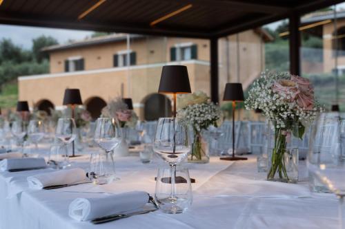a long table with wine glasses and flowers in vases at La Quercetta in Foligno