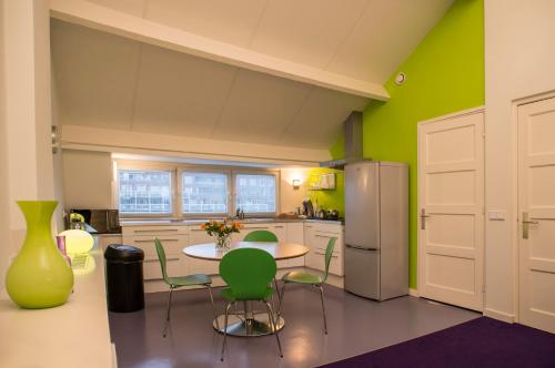 馬斯垂克的住宿－PetitGrandeur，厨房配有桌椅和冰箱。