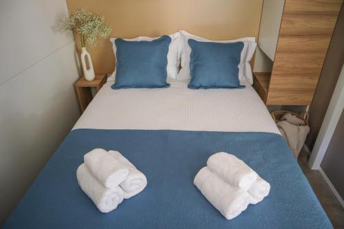 a bedroom with a bed with towels on it at Mobile home MARIS in Sveti Juraj