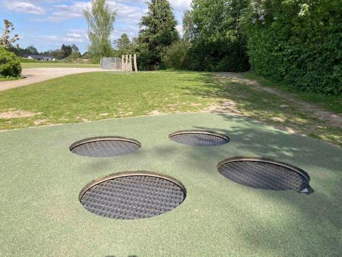 a group of four metal man holes on a putting green at Large modern family room - “Arnely” in Tommerup