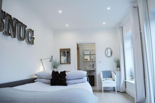 a white bedroom with a bed and a mirror at The Snug in Riccall