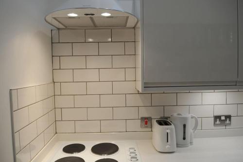 a kitchen with white tiled walls and a counter top at The Snug in Riccall