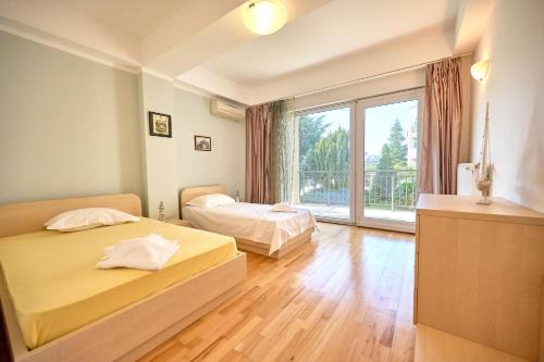 a bedroom with two beds and a large window at SeaX Stay Apartment - free parking in Mamaia Sat/Năvodari