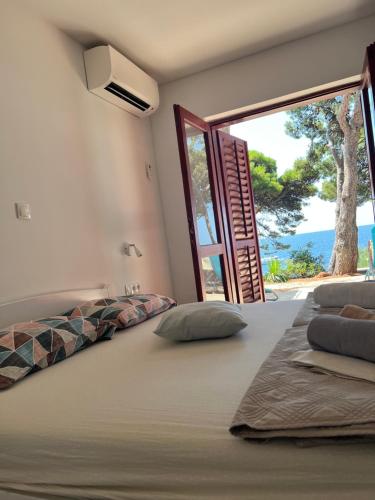 a bedroom with a bed with a view of the ocean at Apartman Zlatan in Sveta Nedelja
