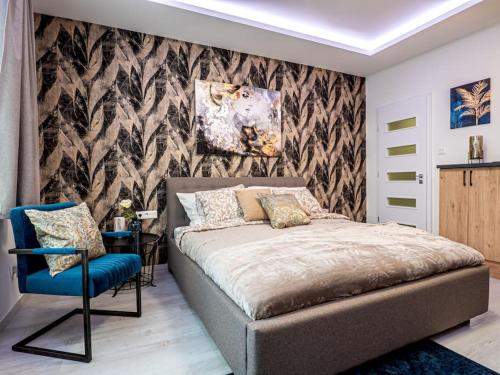 a bedroom with a bed and a blue chair at Vidra-lak with Private Parking in Budapest