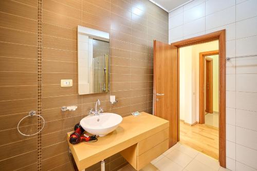 a bathroom with a sink and a mirror at SeaX Stay Apartment - free parking in Mamaia Sat/Năvodari