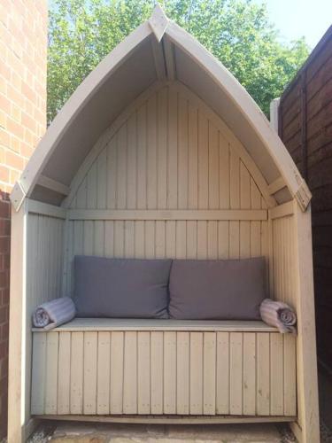 a large wooden dog house with two pillows on it at The Snug in Riccall