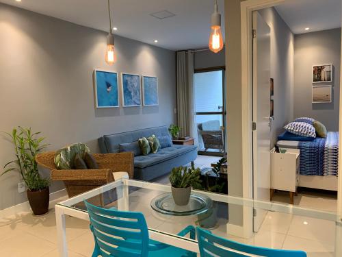 a living room with a glass table and blue chairs at Rio Marina Resort in Itacuruçá