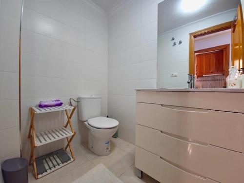 uma casa de banho com um WC, um lavatório e um espelho. em ATICO CON BARBACOA em Torrevieja
