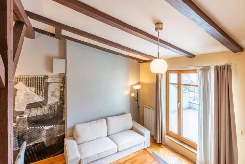 a living room with a white couch and a window at Janackovo - Riverside Residence in Prague