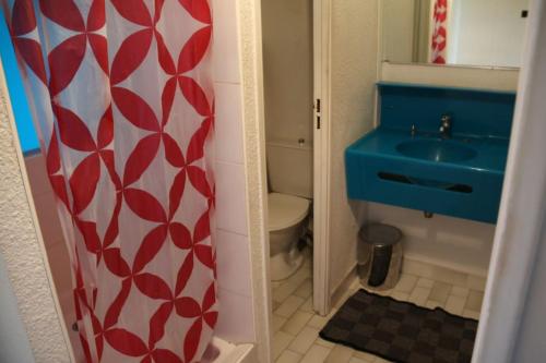 une salle de bain avec un lavabo bleu et des toilettes dans l'établissement Appart 539, Port Nature 5 au village naturiste, au Cap d'Agde