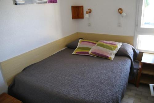 une chambre avec un lit avec deux oreillers dessus dans l'établissement Appart 539, Port Nature 5 au village naturiste, au Cap d'Agde