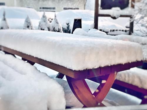 a snow covered picnic table with snow on it at Gasthof Auwirt in Sankt Michael im Lungau