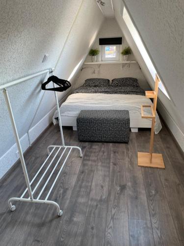 Schlafzimmer im Dachgeschoss mit einem Bett und einer Treppe in der Unterkunft Casa di maksch de miniatura in Amsterdam