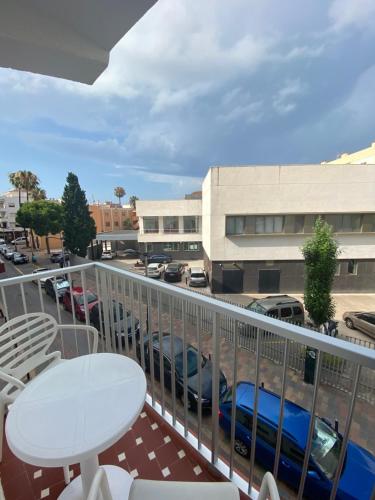 a balcony with a table and chairs and a parking lot at Hotel Playa in Peñíscola